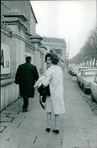 Vintage fotografija Irine Demich hoda na trotoaru, osvrće se natrag.