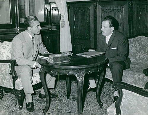 Vintage fotografija Mohammada Reza Shah Pahlavija u razgovoru s čovjekom.